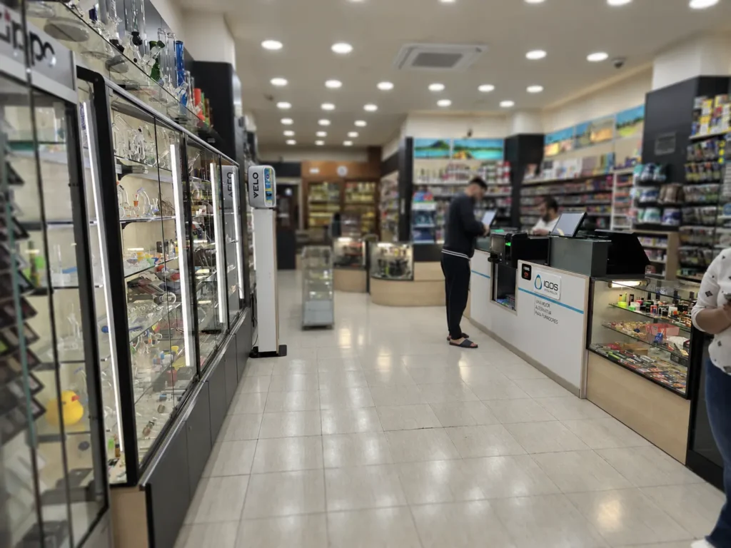 Interior completo de Tabacs Carmen 15 durante una venta real, mostrando el local en funcionamiento, el amplio surtido de productos y la zona de cajas con Strator y gestión inteligente de efectivo.